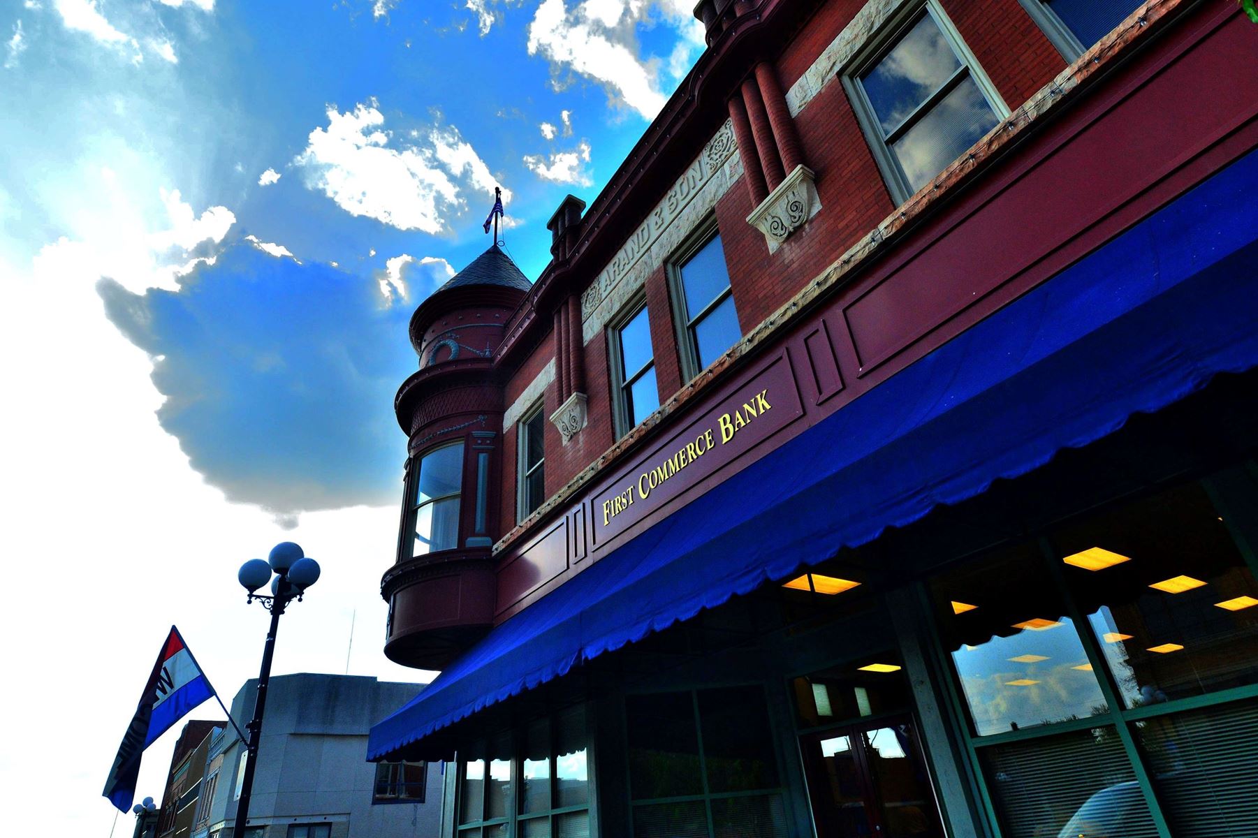 First Commerce Bank building with a cloudy, blue sky in the background